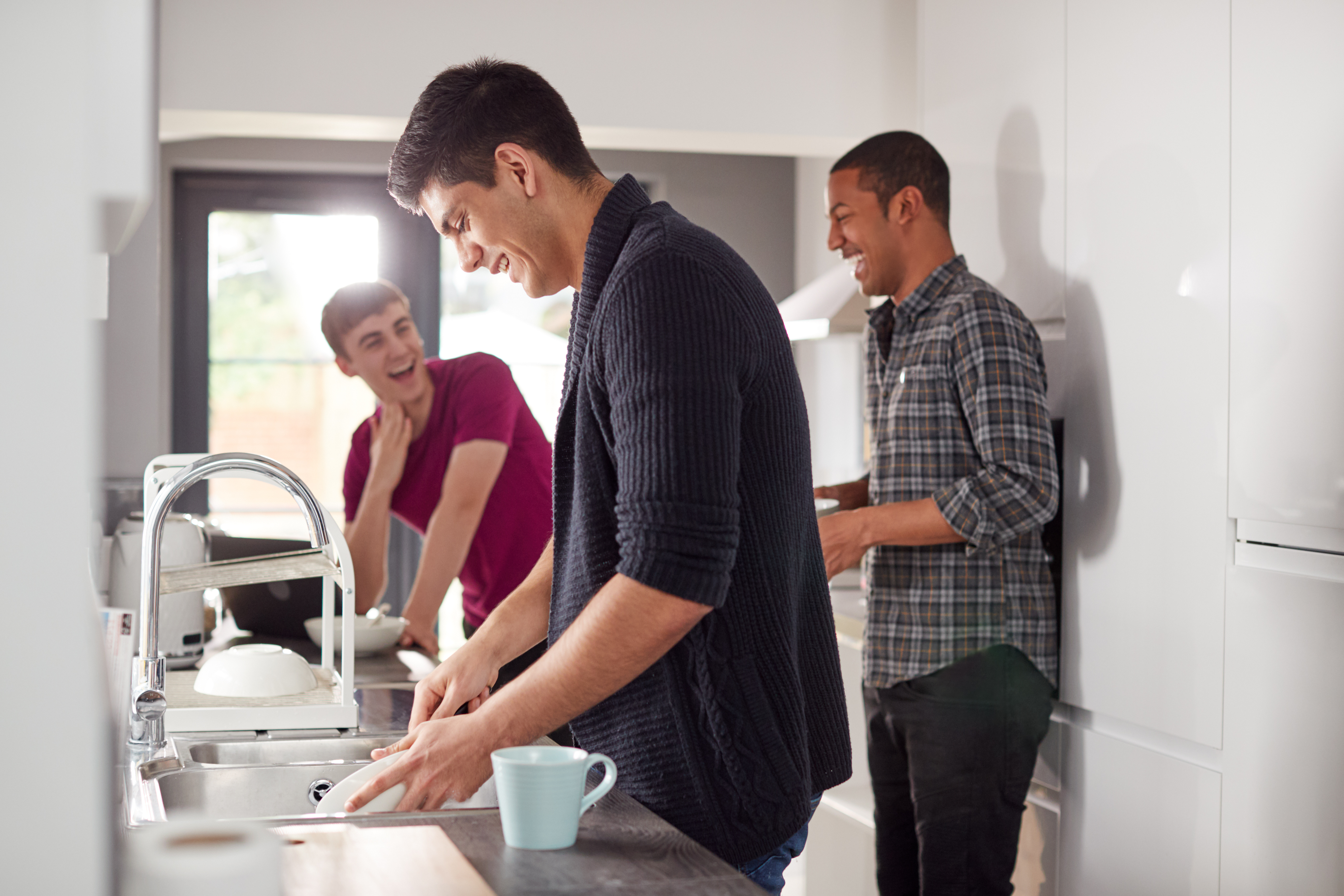 Men in shared transitional housing, spending time together in the kitchen.